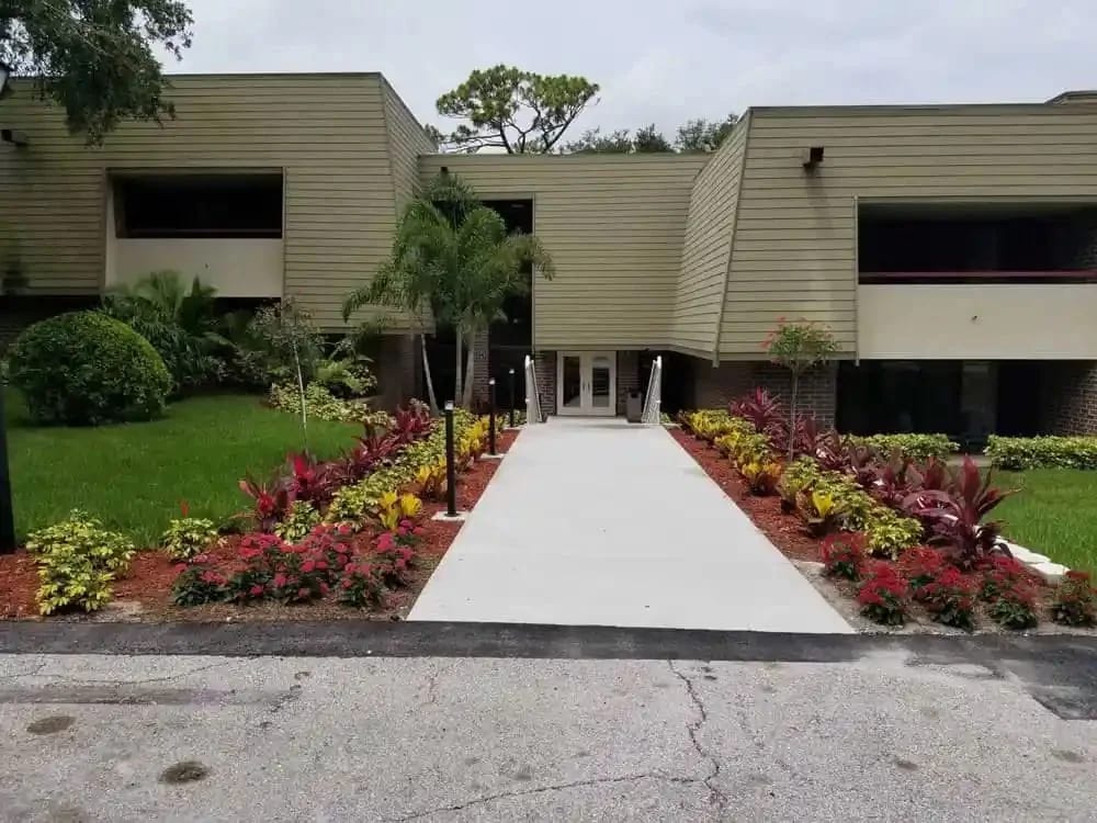 Well-maintained commercial property landscaping in Tampa Bay with manicured turf and fresh seasonal color at the entrance