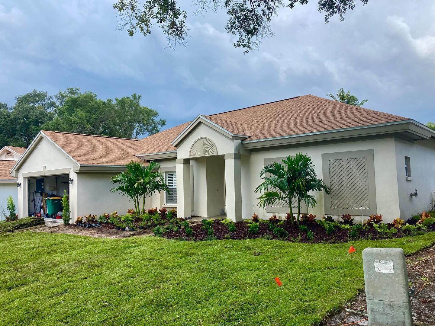 A fixed-up builder-grade front yard in Wesley Chapel with deeper curved beds, layered plants and fresh sod