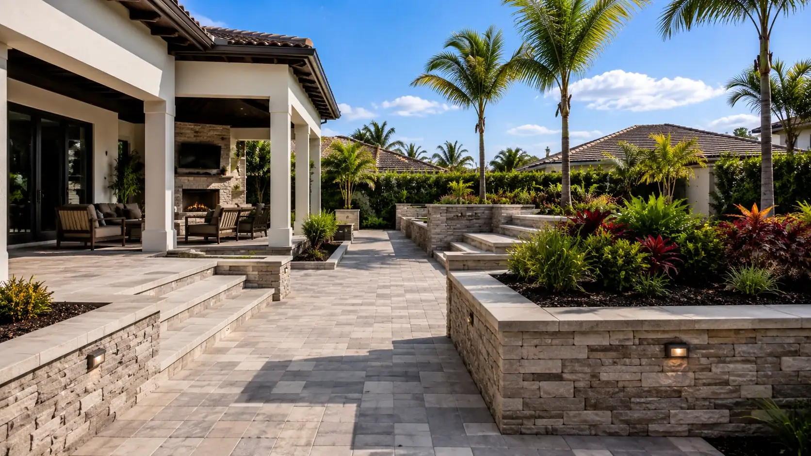 Finished paver patio with tiered stone seat walls and raised planters on a Tampa Bay property