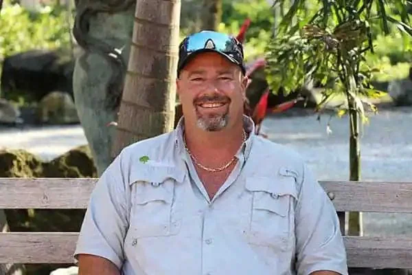 James Slayton, Vice President of Millennium Lawn, Landscape & Nursery, smiling outdoors in a light-colored shirt in front of trees
